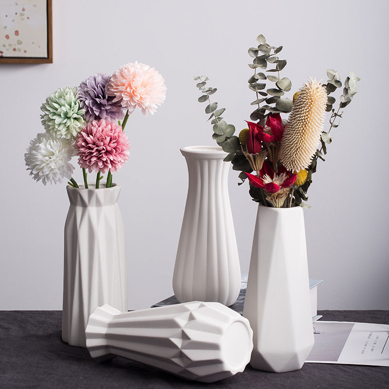 Nordic faceted ceramic vase collection displayed with dried and fresh flowers in a modern minimalist interior